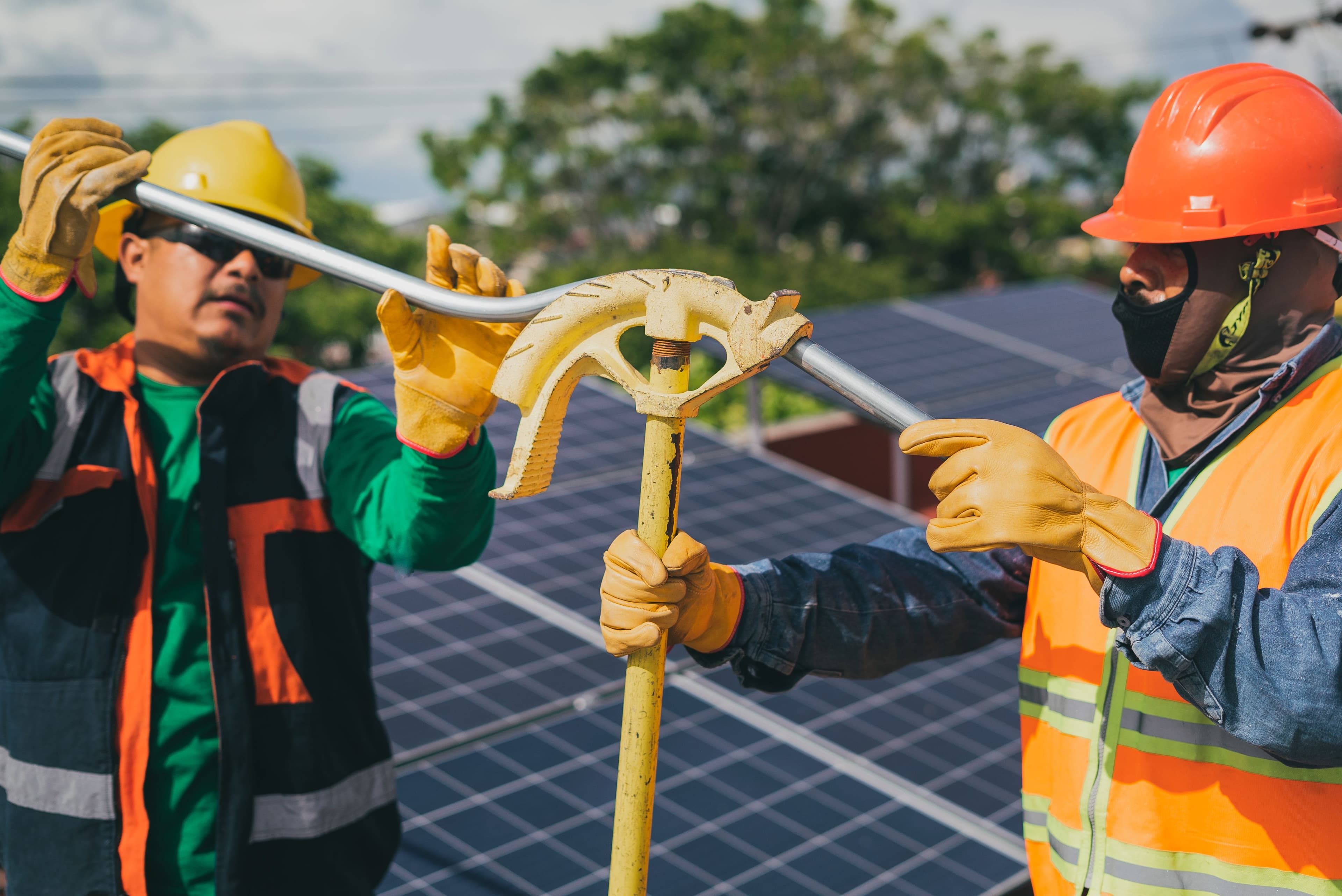 Two contractors working together on a solar panel installation