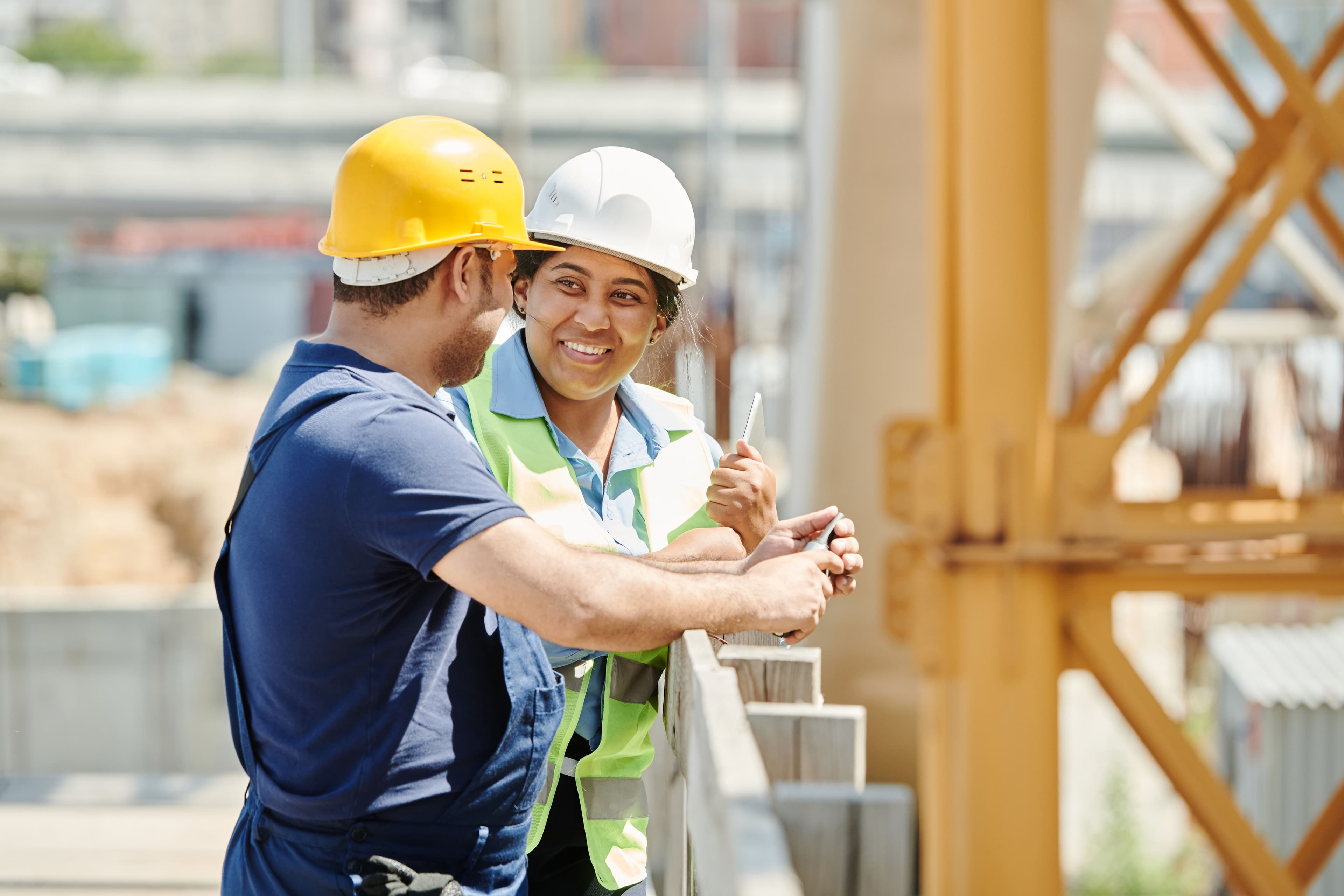 Two contractors talking and smiling at a job site