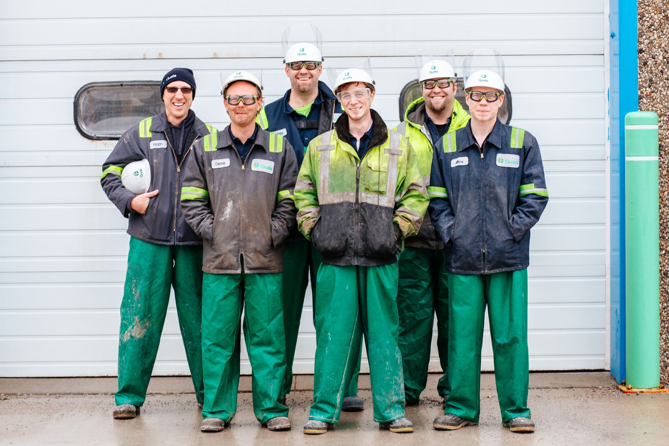 A crew of six posing together in matching uniforms and hard hats